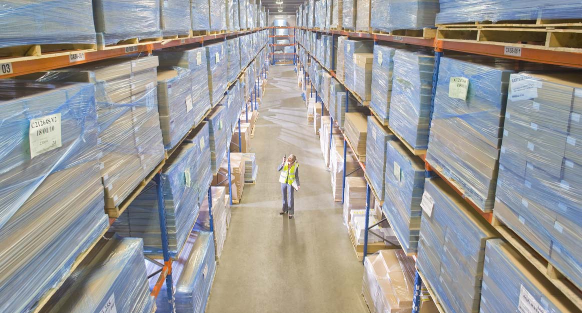 warehouse worker inspects warehouse pallets