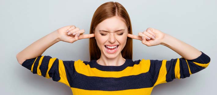 woman with fingers in ears to block noise