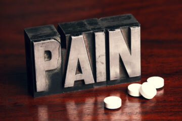 The word pain in large letters, with tablets next to the words.