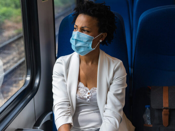 Lady traveling by train wearing a face mask