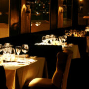 (alt="luxurious empty restaurant, with tables set and ambient lighting")